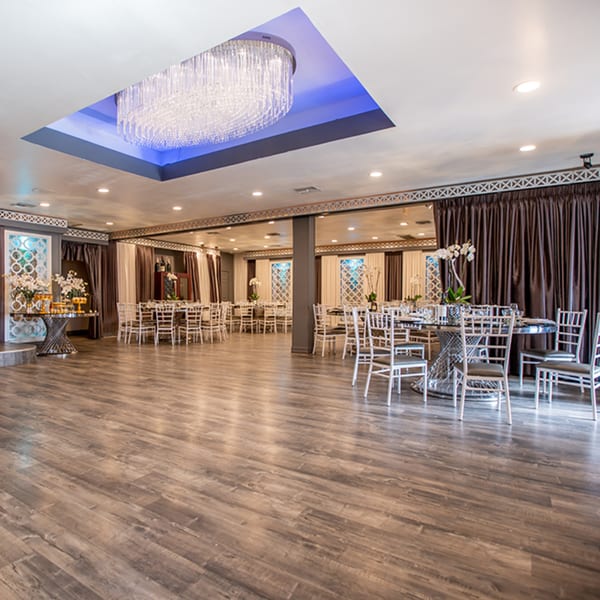 Elegant Fresco Ristorante dining room with chandeliers, dark curtains, and tables set for guests.